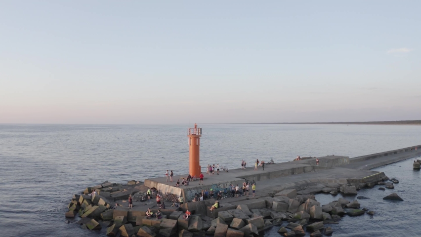 10--05-2021aerial view of stone pier and lighthouse. People at pier waiting for sunset. | Shutterstock HD Video #1082579086