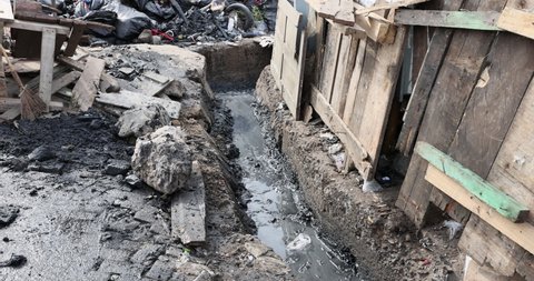 NIMA, GHANA - 30 OCT 2021: Trash garbage sewer ditch drain poverty area Accra Ghana. Busy congested market residential area environment. Pollution and garbage. Low income poverty of Africa. 