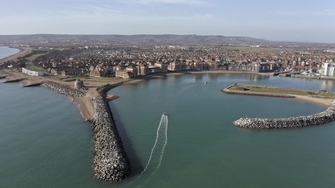Aerial footage of the entrance to Sovereign Harbour in Eastbourne with boats heading towards the Marina.