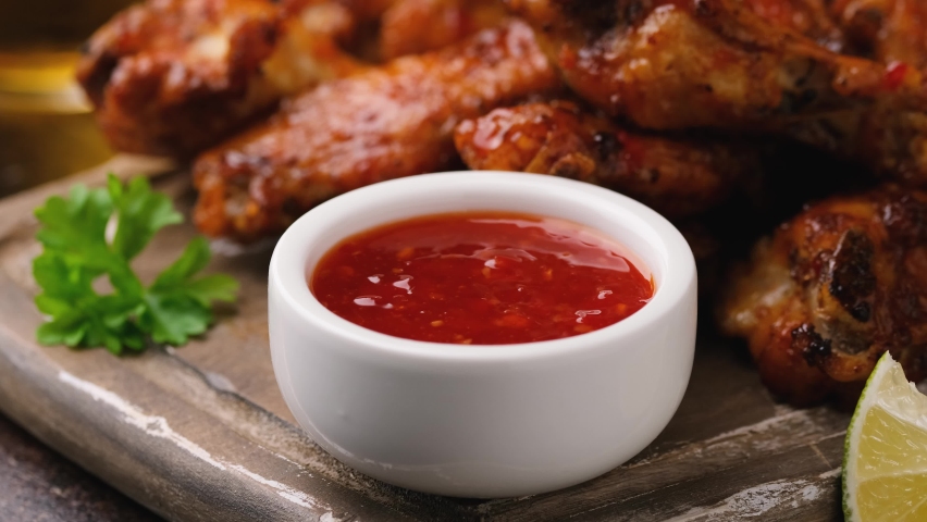 Dipping buffalo chicken wings in sweet chili sauce. fast food. Royalty-Free Stock Footage #1082587870
