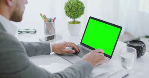 Young Male Professional Writing Important Email From His Home. Remote Working Day Light. Locked Over The Shoulder Shot of Business Caucasian Brunette Man Typing on Laptop. Green Screen.