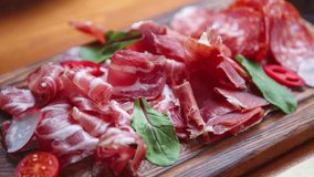Stock food footage with prosciutto ham and jamon cut on slicer for wine snack in meat restaurant. Ultra hd 4k footage
