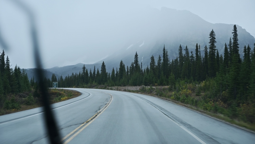 Road trip on highway in rainy and gloomy day at national park