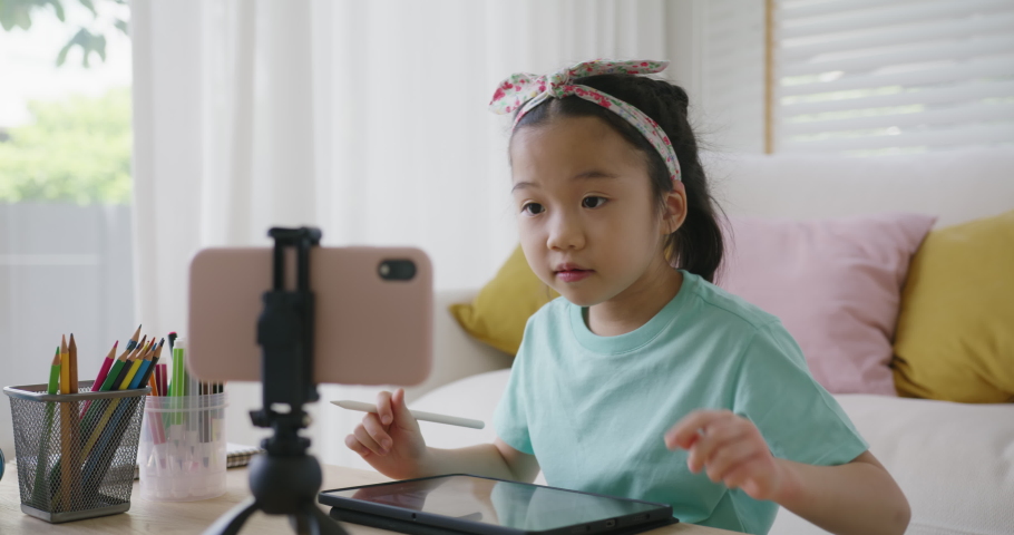 Asia small kid young youtuber vlogger influencer fun live show drawing paint class selfie shoot online VoIP video call social media app. Happy child gen z artist girl play and learn hobby at home.