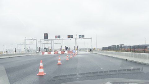 Vendenheim, France - Circa 2021: Driver approaching new Vinci toll road gates during launch day of the Contournement Ouest de Strasbourg A 355 highway