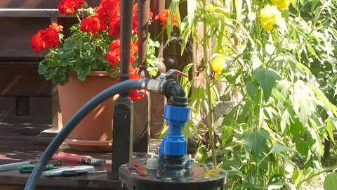 Leakage of water from pipes. A damaged hose of the submersible pump from which a stream of water runs. Repair of the water supply system in the garden area. Damaged water pipe in the irrigation system