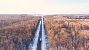 Development of transport infrastructure in the region. Movement of freight transport on federal roads. A snow-covered highway runs through the forest. High quality. 4k footage. - Powered by Shutterstock - Get 15% off with code: PIKWIZARD15
