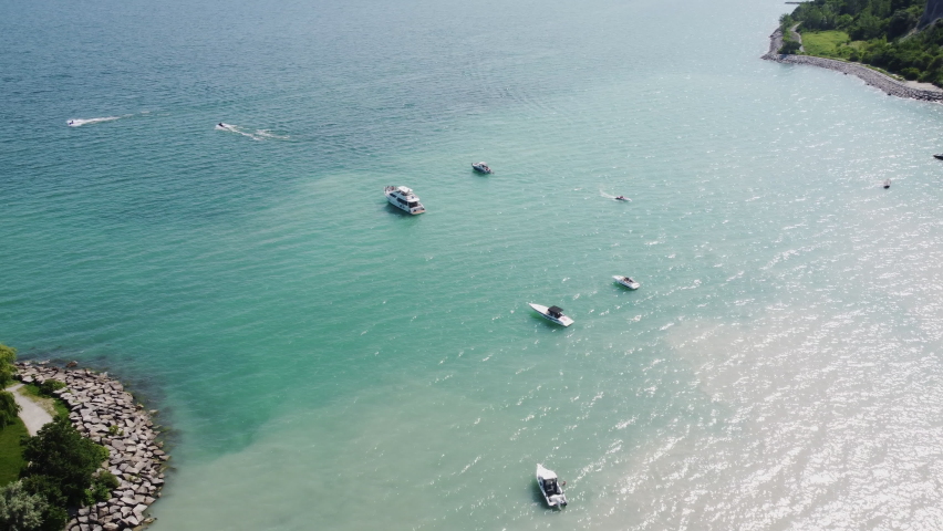 A beautiful view of a beach and small ships swimming in the sea in Toronto, Ontario, Canada