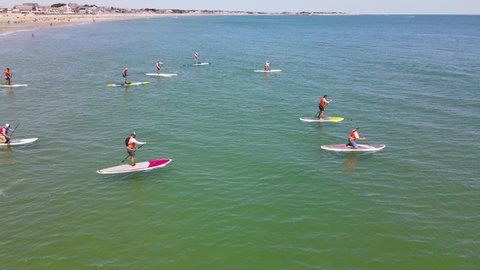Marshfield , Massachusetts , United States - 07 31 2021: Standup Paddleboarders propelling their boards during racing event for raising charity funds. Aerial.