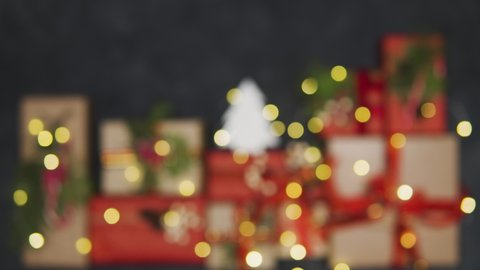 A beautiful Christmas composition of gifts and a miniature Christmas tree is visible against the blurred background. Flashing garlands. Place for your congratulations, place for your text.