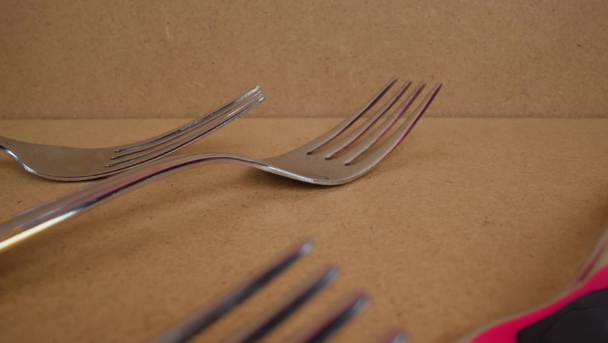 Stainless steel forks lie in cardboard box on table