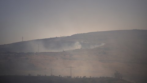 Thick smoke rising above the mountain hill that is burning due to the heat wave. Global warming, climate change concept.