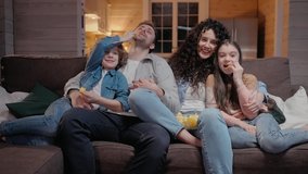 Family watching a movie together at home hugging, eating crisps and laughing. Family spends time together in lockdown. 50fps. High quality 4k footage - Powered by Shutterstock - Get 15% off with code: PIKWIZARD15