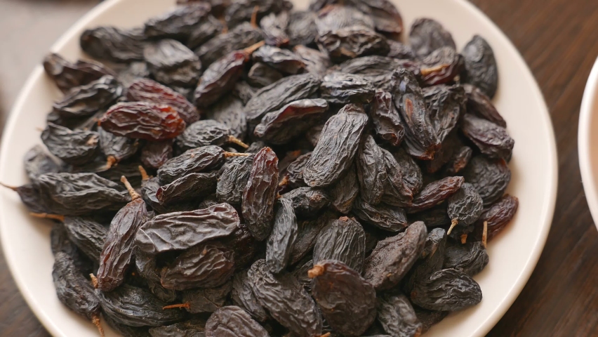 Dry raisins in a white plate | Shutterstock HD Video #1082666566