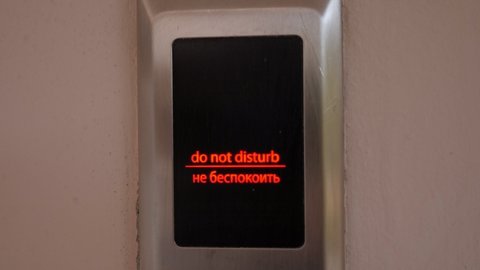 The DO NOT DISTURB sign is lit on the electronic scoreboard on the door of the hotel.