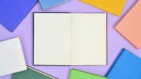 6k Deep blue hardcover book appear on purple theme and opens and vibrant colors books appear around make frame. Stop motion flat lay - Powered by Shutterstock - Get 15% off with code: PIKWIZARD15