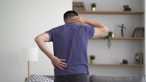Back pain, man with backache at home, health problems concept