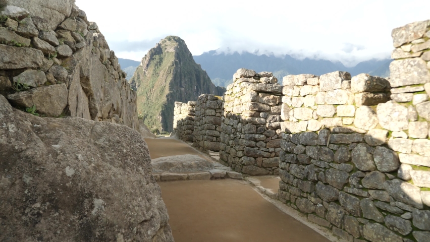Walking through the ruins of Machu Picchu, Peru. Machu Picchu, the lost city of the Andes, located above the Sacred Valley of Cuzco, Urubamba, Peru.