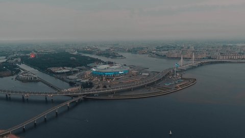 Russia, St. Petersburg, 11 September 2021: Aerial footage of stadium Gazprom Arena, new landmarks of Saint Petersburg in evening, night illumination of building, cable bridge, highway, coastline