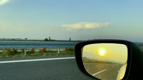 Sunset in Rear View Mirror in Car When Driving