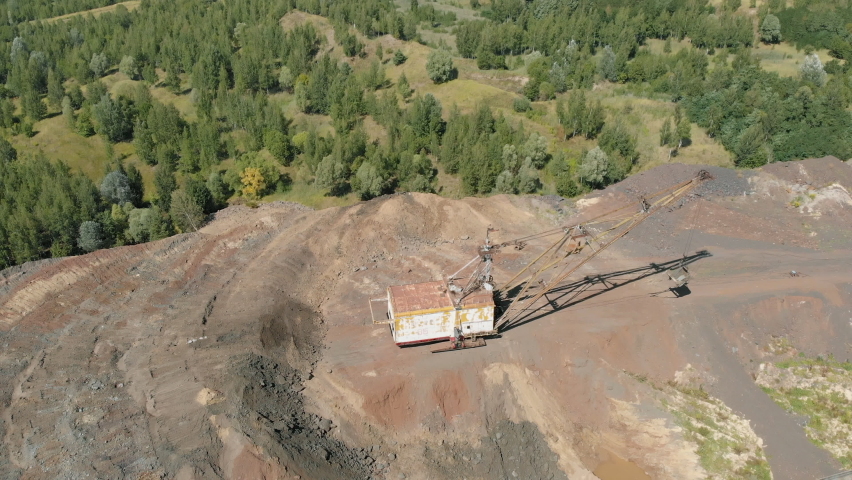 A huge excavator is collecting ore in a bucket . Mining operations.