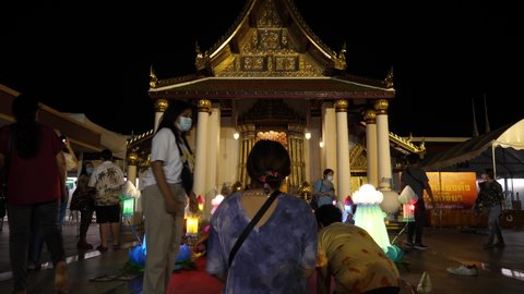 PHITSANULOK, THAILAND November 19, 2021: Person to pay respect Phra Buddha Chinnarat sculpture at Wat Phar Sri Rattana Mahathat woramahawihan temple.  Loy Krathong Festival in night. Time Lapse.