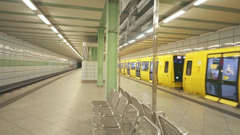 BERLIN, GERMANY - Nov 5, 2021: Yellow train in empty Berlin metro platform, U Bahn underground subway. German urban lifestyle, tourism destination in Germany.