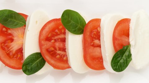 Cheese and tomatoes with spinach leaves, top view. Caprese salad.