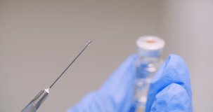 Extreme Close Up of Hand Holding Syringe and Vaccine in Hand in Laboratory 