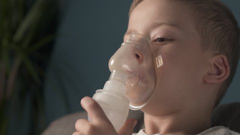The child does the lung inhalation procedure at home. Inhalation when coughing. Cough treatment in children. Nebulizer inhalation at home