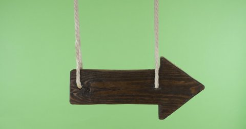 Empty swinging wooden sign hung from ropes. With space for design, text place. Isolated on green screen
