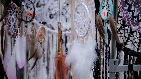 Many different amulets Dreamcatcher swinging in the wind. Beautiful multicolored feathers flying in the wind. 50 fps