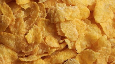 Golden dry corn flakes extreme close up rotating very slowly stock footage
