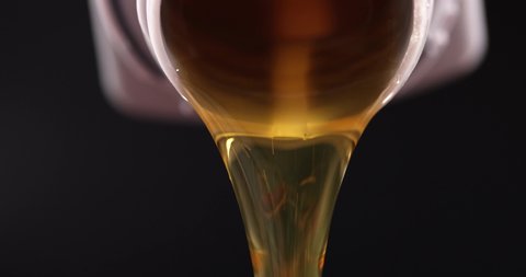Clear yellow oil is pouring from plastic bottle slow motion 4k movie
