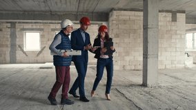 Wide shot video of group of  caucasian engineers and investors walking and discussing on construction site. Shot with RED helium camera in 8K