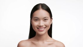 Happy Asian Young Woman Smiling To Camera Posing Standing Shirtless Over White Studio Background. Beauty Portrait Of Attractive Millennial Korean Female. Facial Skincare Concept