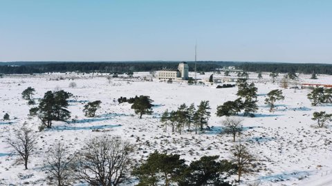 Aerial drone 4K orbiting footage of Radio Kootwijk transmitter tower in Veluwe nature reserve, Netherlands. Old cathedral in an idyllic snowy landscape. Able to communicate with Duch Indies colony.