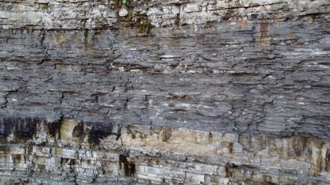 geological rock strata, colored stratified rock layers in the escarpment. descending aerial view