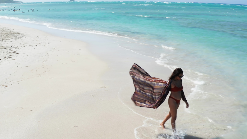 Solo woman in bikini on idyllic white sand beach at Playa Teco Maimon, Dominican Republic