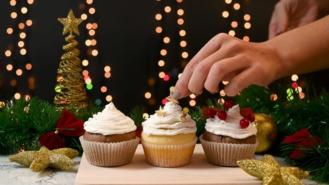 Making homemade Christmas delicious cup cakes and decorating with gold stars
