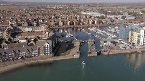 Sovereign Harbour near Eastbourne with a boat entering the lock entrance to the marina, Aerial Footage.