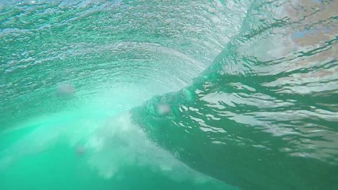 UNDERWATER SLOW MOTION: Beautiful big tube wave breaking over camera in crystal clear ocean in Canary Islands