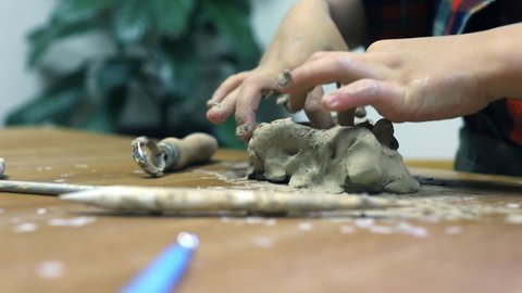 hands of a girl sculpting clay