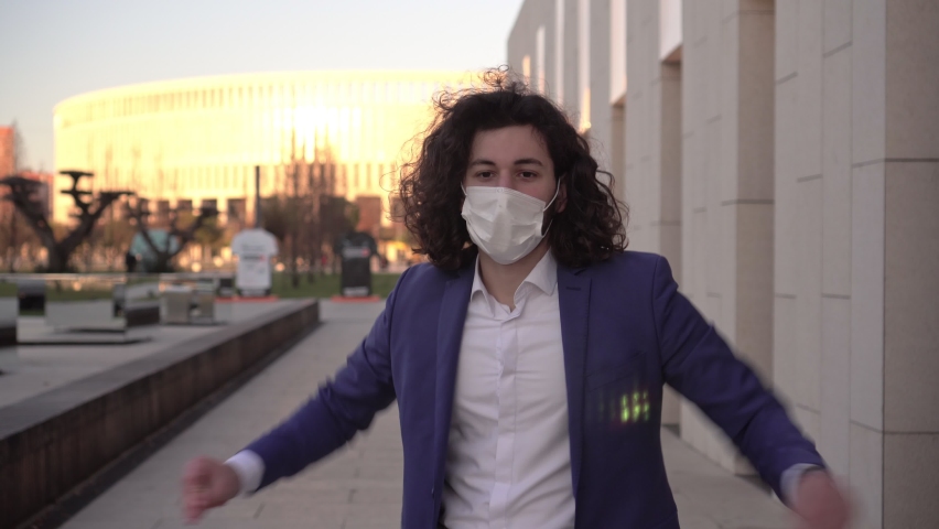 Happy man takes off his medical mask. businessman takes off the protective mask from the coronavirus. The end of the coronavirus, life after the pandemic