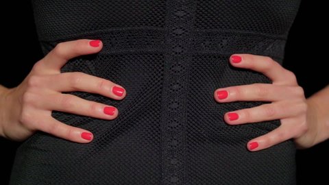 Close-up of woman's hands with red nails,impatiently and passionately tapping her fingers on waist,tightened in black corset of mesh dance dress.Erotic sexy clothes and underwear,hot girl concept.