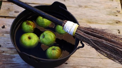 Apple bobbing at Halloween with witches broomstick medium shot slow motion selective focus