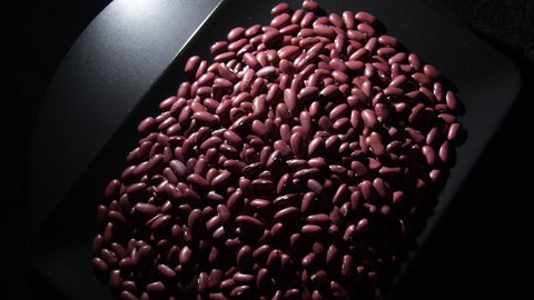 Red beans legumes in a black tray, rotation