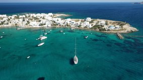 Aerial drone video of picturesque fishing village of Polonia or Pollonia with traditional fishing boats anchored next to island of Kimolos, Milos island, Cyclades, Greece