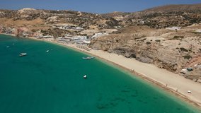 Aerial drone video of scenic colourful volcanic rocky bay and emerald sandy beach of Paleochori a natural vacation paradise with resorts and water sport facilities in island of Milos, Cyclades, Greece