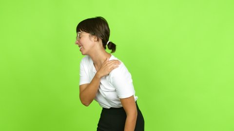 Young woman with shoulder pain over isolated background. Green screen chroma key